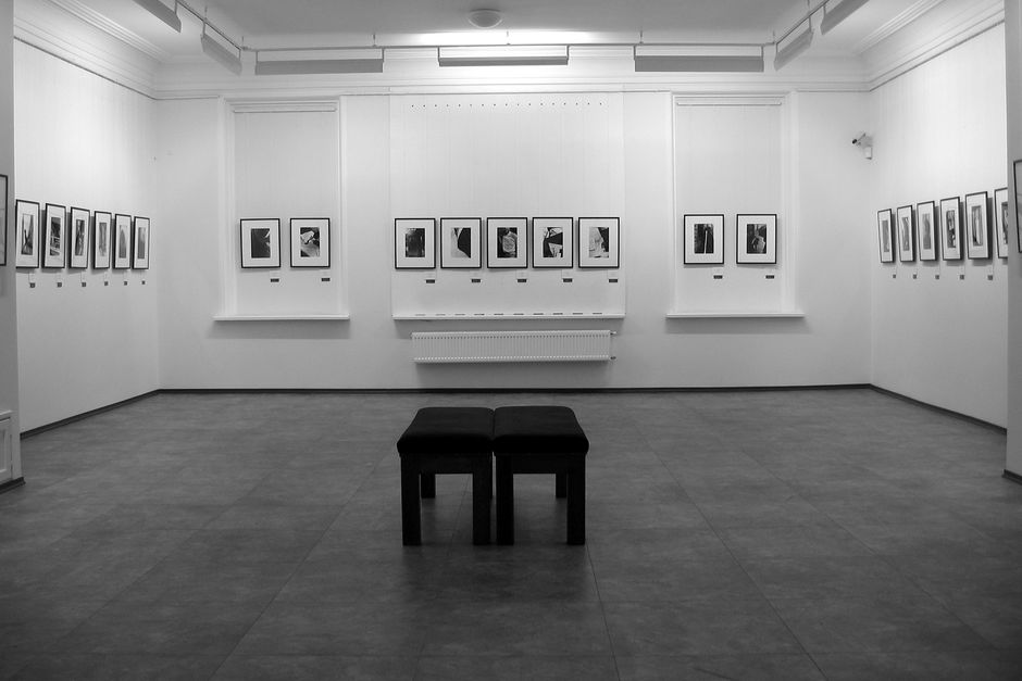 Empty modern art gallery interior highlighting minimalist framed photography on white walls.