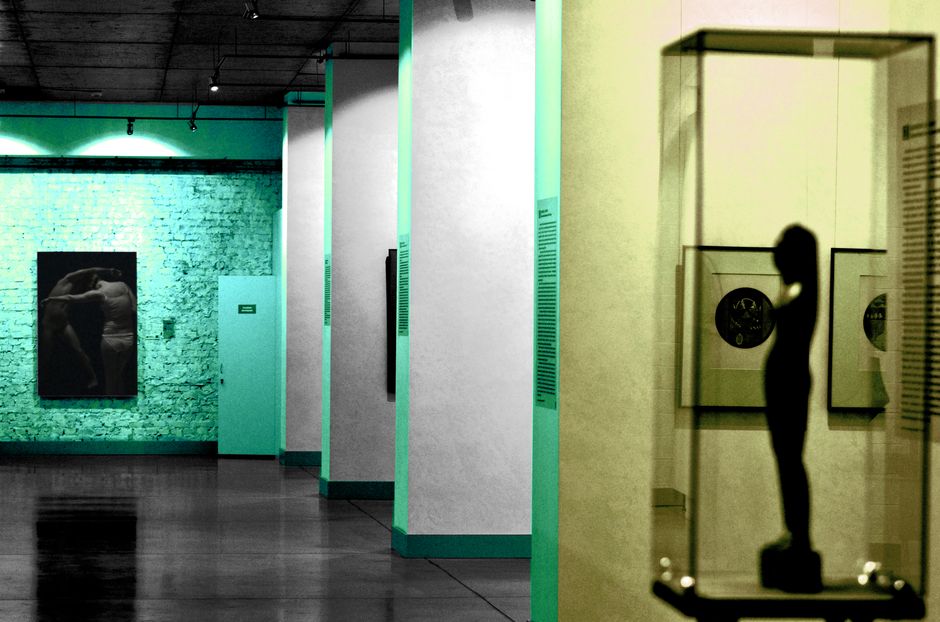 Explore a modern art gallery featuring sculptures and paintings under ambient lighting.