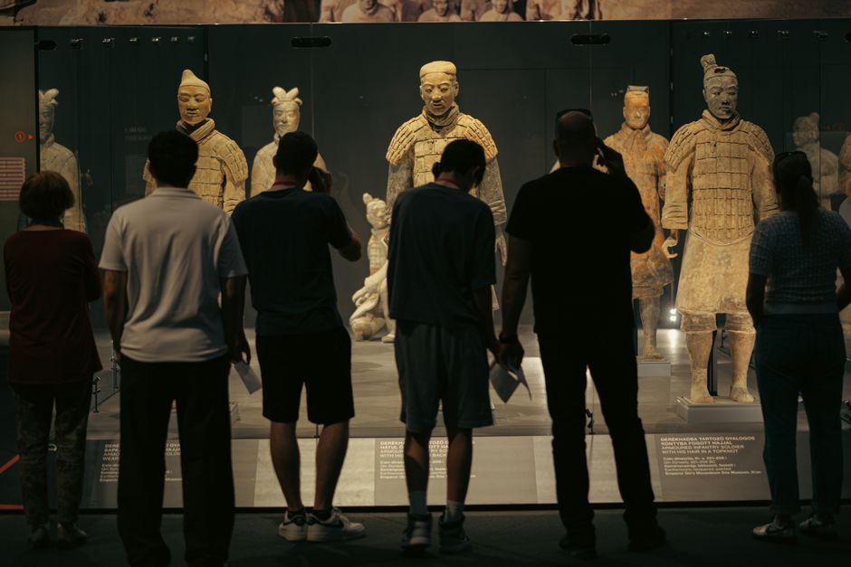 People observing the Terracotta Warriors exhibit at a museum in Budapest, Hungary.